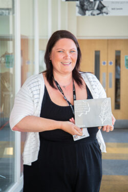 Teacher, Becky Smith holding her Pearson Teaching award.